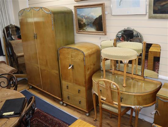 A 1930s blond walnut seven-piece bedroom suite decorated with silvered metal swags,